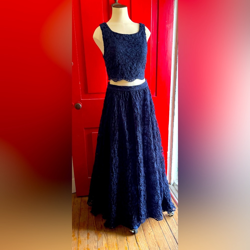 ELEGANT two-piece gown features afull skirt adorned w/ luxurious dark blue lace